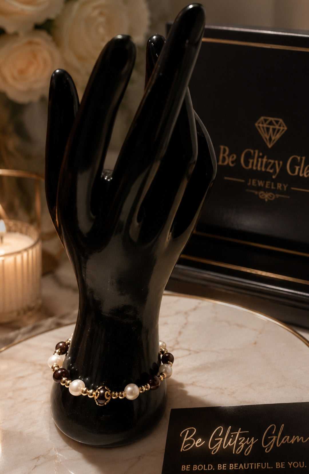Crimson and pearl bracelet with gold accent beads displayed on a black hand jewelry stand