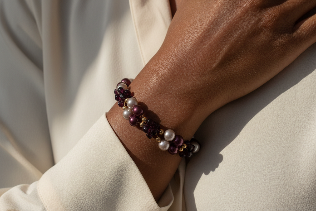 Black woman wearing plum pearl and gold bracelet