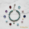 Birthstones and matching pearls flat lay