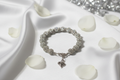 Crystal rhinestone disco ball heart charm bracelet on white satin with rose petals